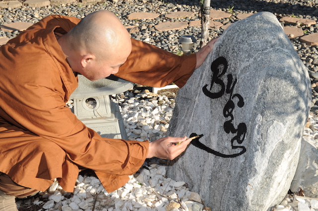 Đại đức Thích Giác Thiện viết chữ trên đá