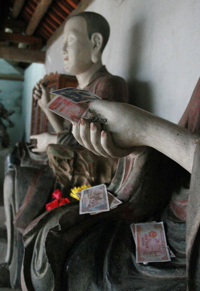 Tiền lẻ &quot;tấn công&quot; tượng Phật trong di tích quốc gia