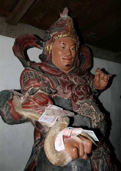 Tiền lẻ &quot;tấn công&quot; tượng Phật trong di tích quốc gia